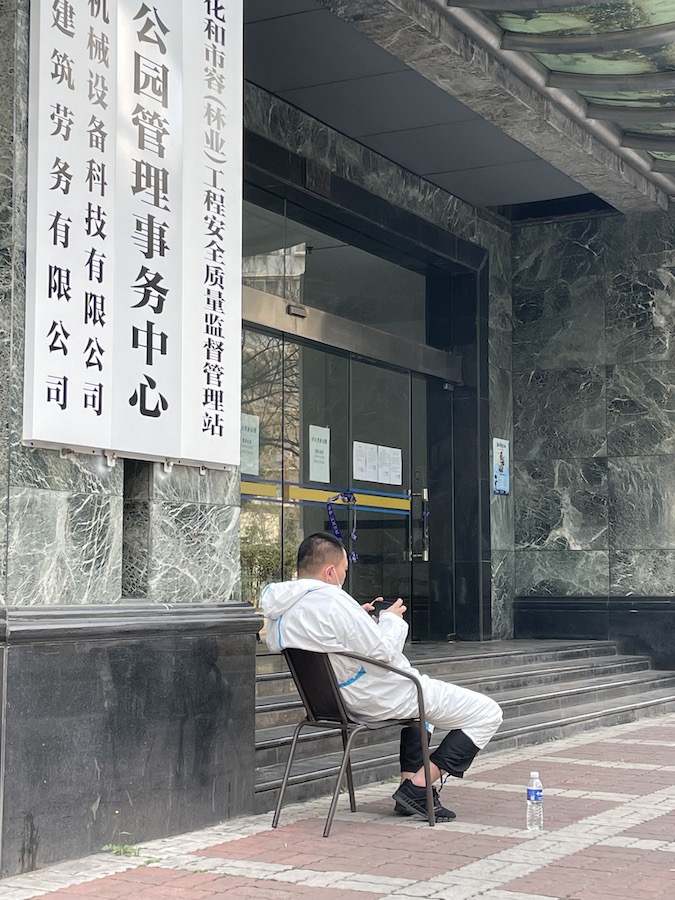 A medical worker looks at his phone during China's latest Omicron COVID-19 outbreak. onaroadtonowhere.com