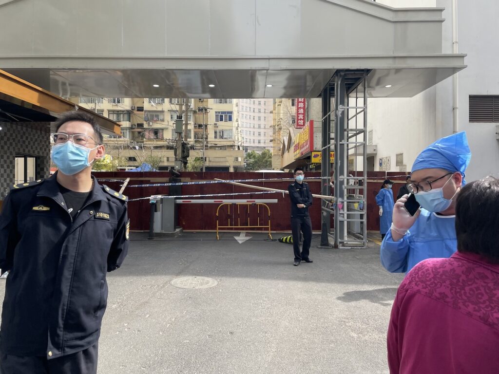 A Chinese policeman stands in front of a barricaded gate during the latest COVID-19 Omicron outbreak. onaroadtonowhere.com