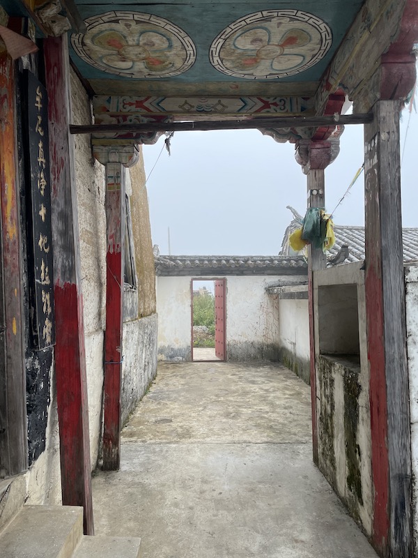 Doorway in Tibetan Buddhist Temple looking out on white mist