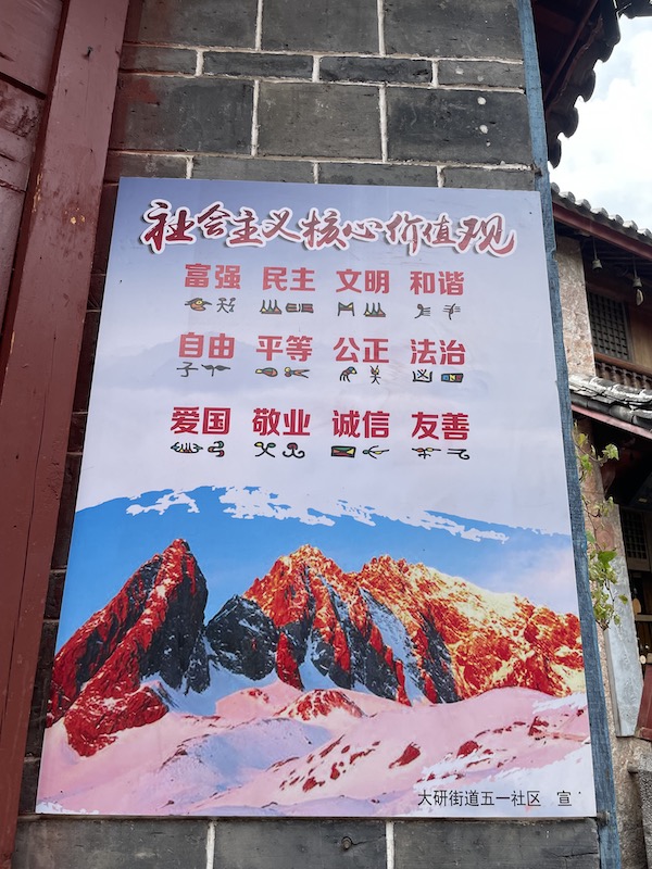 Naxi writing on principles of Chinese socialism poster in Lijiang China