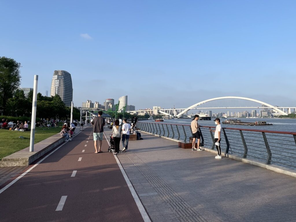 People walk along the waterfront at the West Bund in Shanghai.