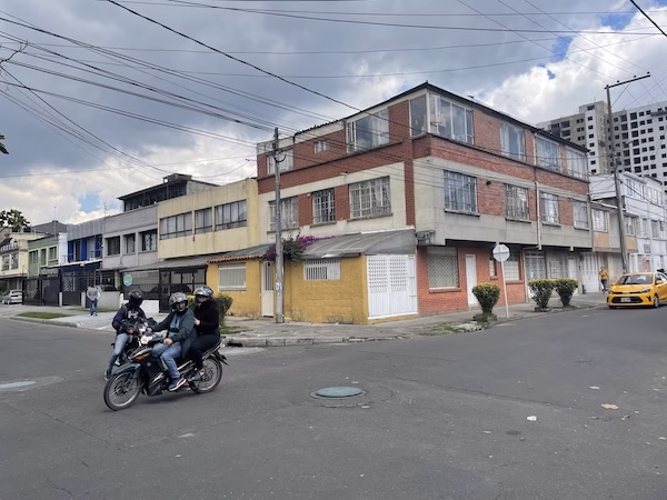 Men ride a motorcycle on a street in Latin America
