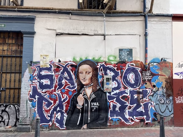 Graffiti of a punk rock Mona Lisa giving the middle finger