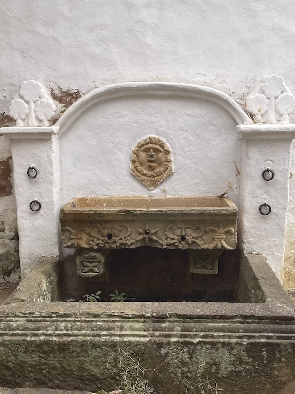 A Spanish colonial era fountain with a strange face and basin in Villa de Leyva, Colombia