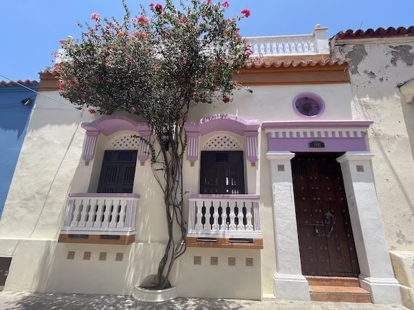A Spanish colonial building with a flowering tree out front
