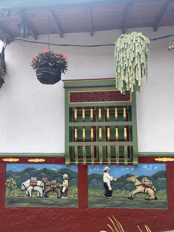 A colorful zócalo featuring men leading donkeys