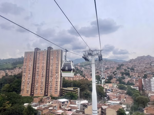 A cable car in front of a high rise apartment in Medellin