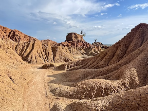 Trail through red rock formations near El Cusco in the red desert section of the Tatacoa Desert, Colombia.