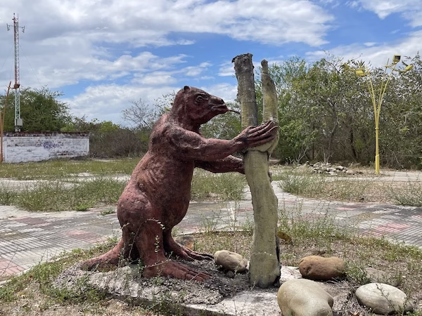 A statue of a sloth licking a tree in Villavieja, Colombia.