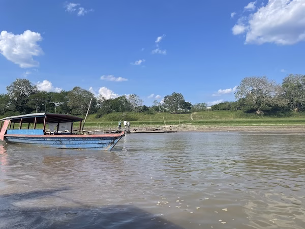A blue boat floats down the Amazon River in Colombia