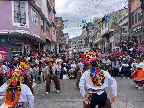 A parade featuring Ecuadorians in traditional costumes.