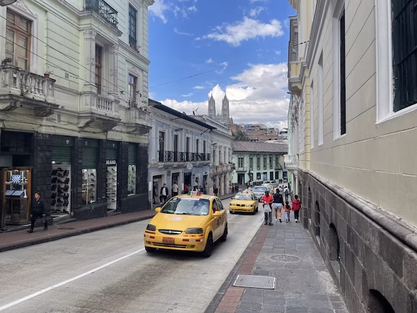 A yellow taxi on an old colonial street