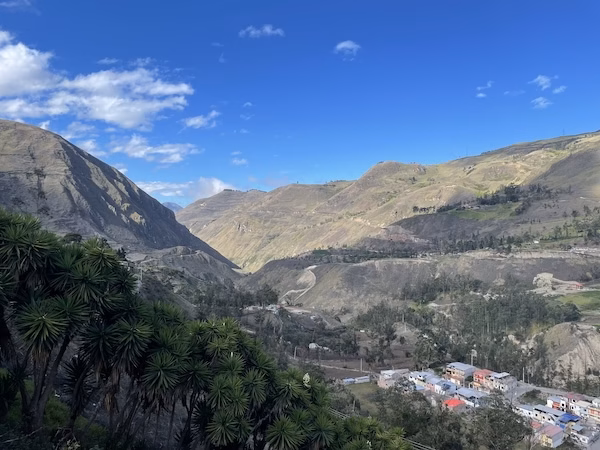 A view of the Andes mountains with a town and buildings in the foreground.