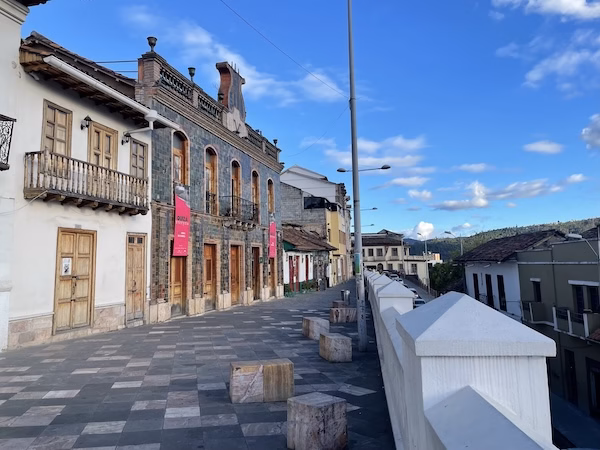 Spanish colonial buildings overlook a stone street on Calle Larga in Cuenca