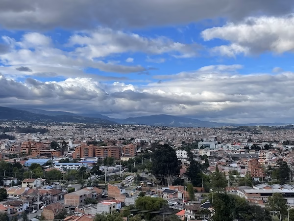 Skyline of Cuenca, Ecuador with clouds and mountains in the background