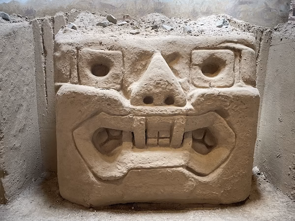 A stone carved into an angry face figure
