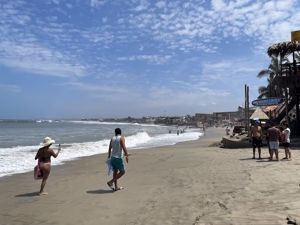 A couple walks along the beach in Mancora, Peru