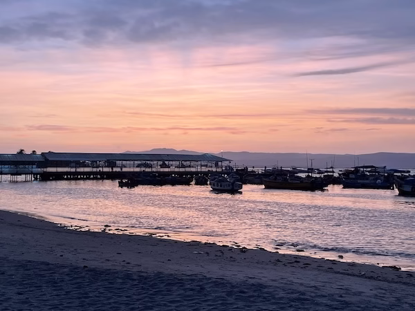 Sunset over a harbor full of small fishing boats on the Pacific Ocean