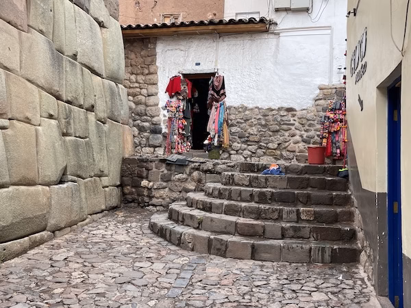 A shop sells souvenirs next to an ancient Inca stone wall in Cusco