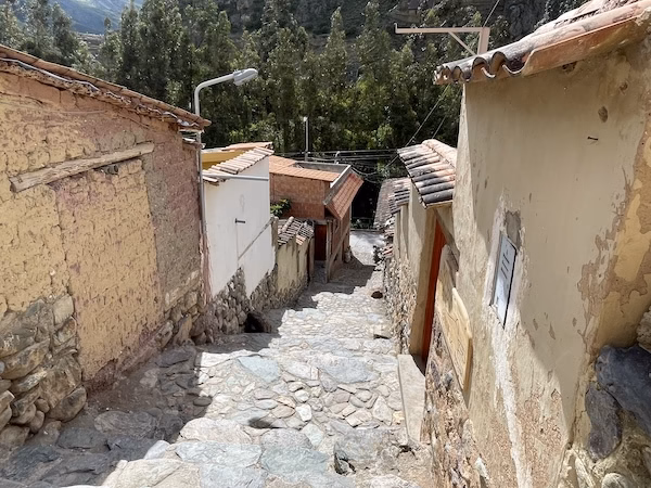 A narrow stone street between buildings in Ollantaytambo