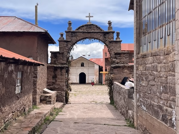 A stone archway frames a building on the island of Taquile